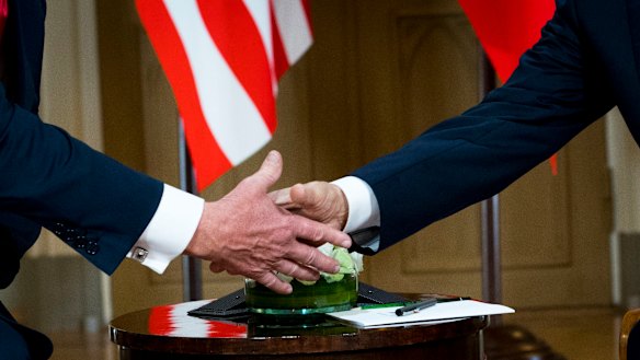 President Donald Trump shakes hands with Russian President Vladimir Putin on Monday.