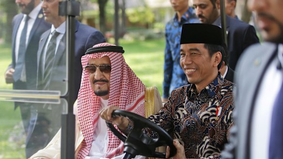 Saudi King Salman, left, rides on a golf cart with Indonesian President Joko Widodo.