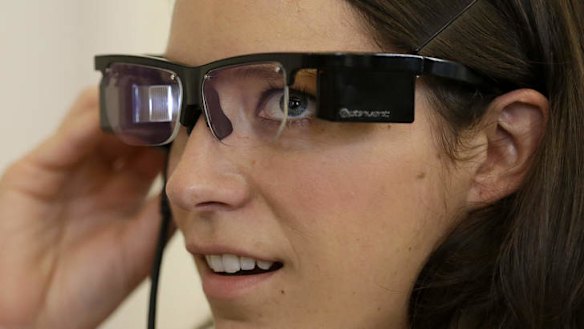 Claire Collins is given a demonstration of Optinvent ORA-S augmented reality glasses at the GLAZED Conference, a conference for the business of wearable technology, in San Francisco.