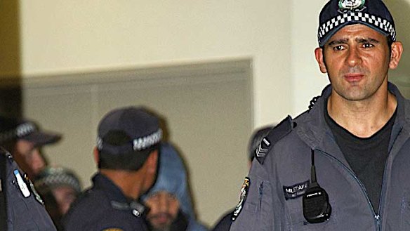 Heavy guard ... Mr Naden is taken from Manning Base Hospital after having stitches for a police dog bite.