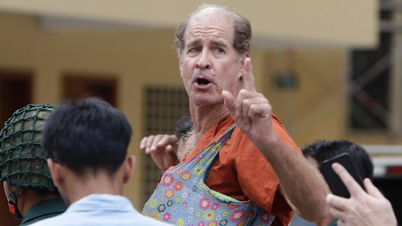 Australian filmmaker James Ricketson gestures as he is escorted by prison guards at the Cambodian Supreme Court in Phnom Penh, Cambodia.