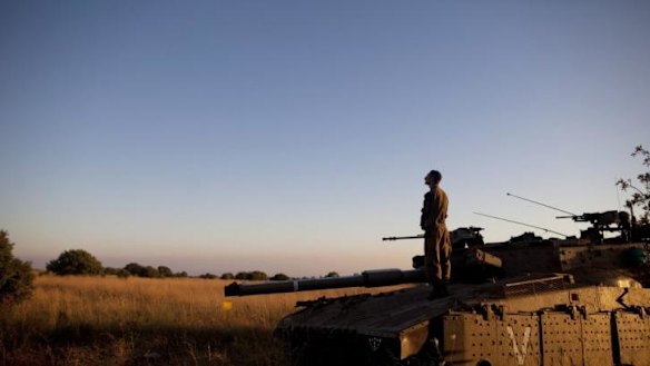 Praying: An Israeli soldier on a Merkava tank near the Israeli-Syrian border. An Israeli teen was killed that day in an attack near the border in the annexed Golan Heights. 