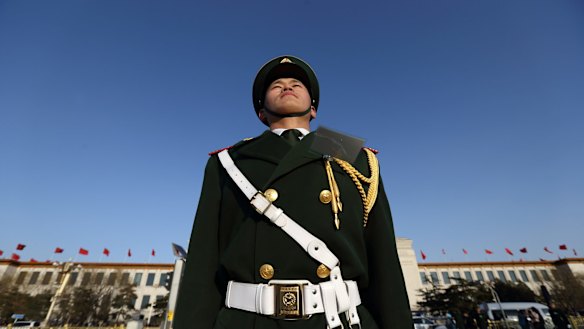 A paramilitary police officer stands outside the Great Hall of the People in Beijing, China.