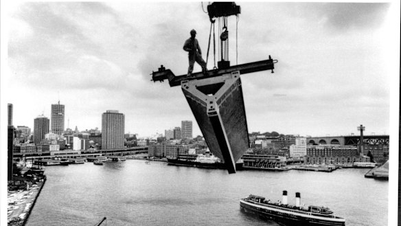 A roof section is lifted over Circular Quay during the  Sydney Opera House construction in 1967.
