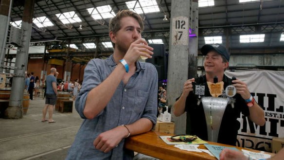 Cider fan Duncan Bell enjoys a drink while Cider Australia president Sam Reid looks on.