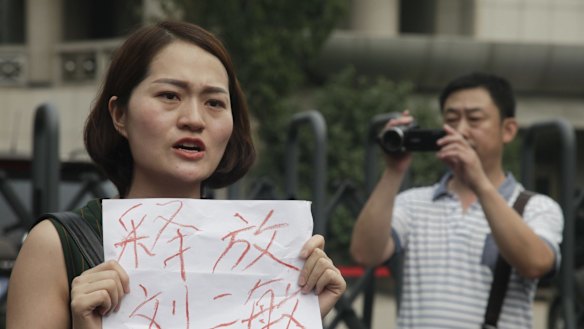 Li Wenzu, wife of imprisoned lawyer Wang Quanzhang, holds a sign that reads "Release Liu Ermin" outside the Tianjin court. Liu Ermin is the wife of one of the arrested activists.