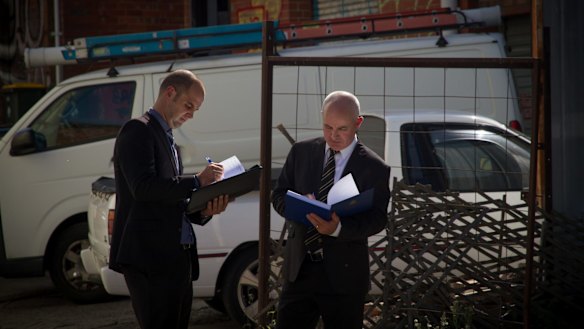 Paul Rowe (left) and Dave Butler typify the public's idea of homicide squad detectives, carrying bound folders and wearing darks suits.