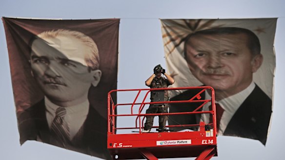 A policeman between portraits of Turkish President Recep Tayyip Erdogan, right, and the republic's founder, Mustafa Kemal "Ataturk".