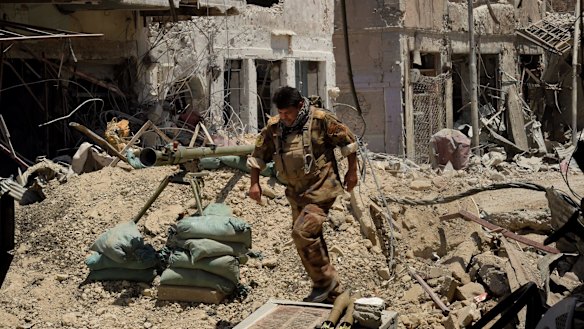 Lieutenant-Colonel Saeed Bader Kathem moves away from the blast range of a planned detonation of one of six IEDs on a road in West Mosul.