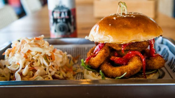 Seafood burger with crumbed calamari and slow-roasted peppers, and a side of coleslaw.