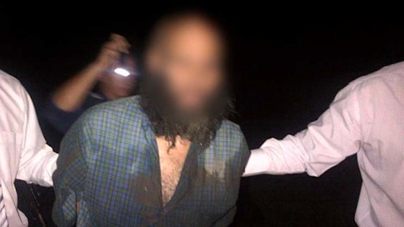 Seven years on the run ... Malcom Naden is taken away after being captured by police.