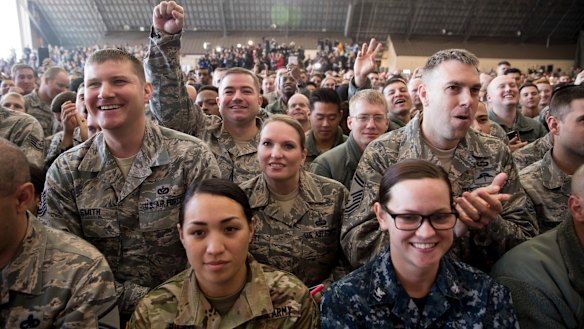 Members of the audience watch as the president speaks at a hanger rally at Yokota Air Base.