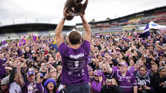 Melbourne Storm second-rower Ryan Hoffman holds aloft the 2009 NRL premiership trophy in front of the team's loyal fans in Melbourne.