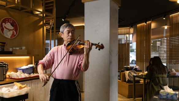 Owner Xiao Tang Qin entertains diners with his violin.