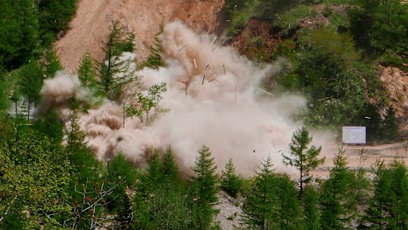 Smoke and debris rise in the air as an observation post next to the entrance of the north tunnel at North Korea's nuclear test site is blown up.