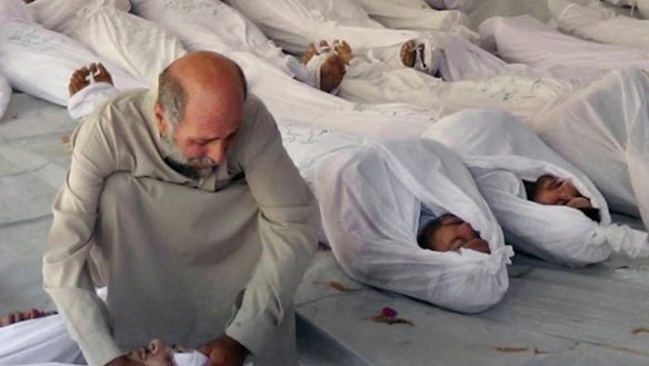 A Syrian man mourning over a body after an alleged poisonous gas attack fired by government forces, according to activists, in Douma, Syria in 2013. 