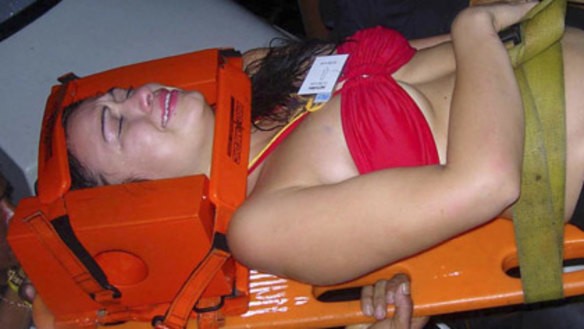 Rescue workers carry an injured woman to a hospital.