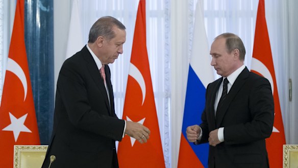 All good now? Russian President Vladimir Putin, right, and Turkish President Recep Tayyip Erdogan shake hands during a news conference.