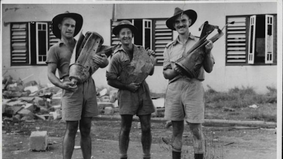At least 14 Japanese fighters and bombers were shot out of action when 49 enemy planes raided Darwin on March 15. In this photo, Pte. F. Conlin, Driver J. Hankin and Sergeant Babb hold parts of Japanese bombs dropped during the raid.