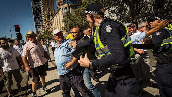 Taxi drivers are seen remonstrating with police during a protest outside State Parliament