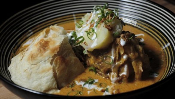 Massaman lamb shank served with mashed potato and roti bread.