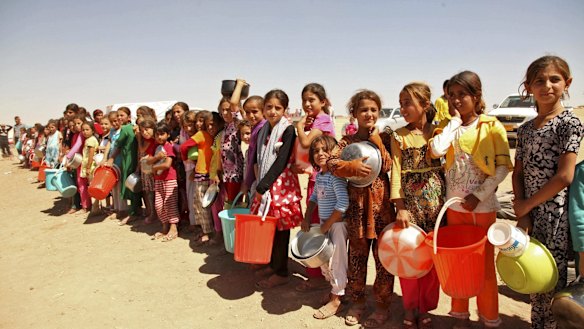 Yazidis fleeing violence in the Iraqi town of Sinjar west of Mosul last year line up for food. 