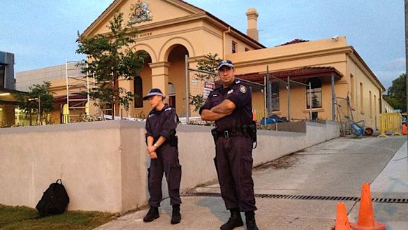 Arrested ... police stand guard outside Taree police station where Malcolm Naden is being held.