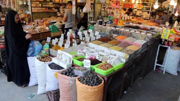 Fears growing: an Iraqi woman buys food at a market in Baghdad, Iraq.