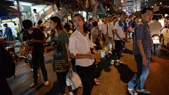 Thai residents wait for transportation to return home home after a curfew was imposed following Thailand's army chief's announcement that the armed forces were seizing power, in Bangkok.