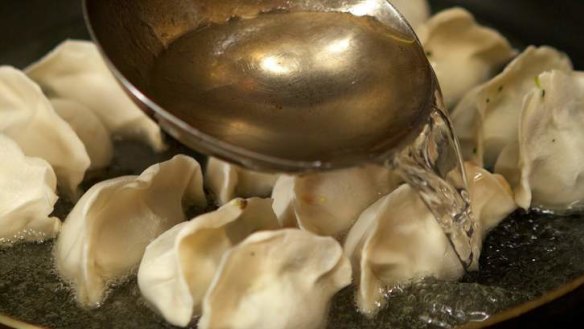 Sammy Shi from Shanghai Street in Melbourne fries the bottom of the dumplings until golden, before placing a lid on the fry pan and cooking them through.