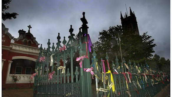 Ribbons tied to the fence at St Alipius Presbytery, church and old boys school in Ballarat pay tribute to the victims and survivors of child abuse. 