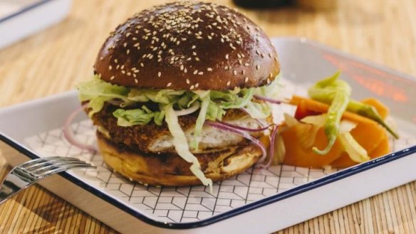 Panko-crumbed flounder burger with red onion, lettuce and lime aioli in a brioche bun.