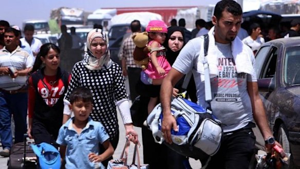 Iraqi families fleeing the fighting in Mosul gather at a checkpoint run by Kurdish forces.