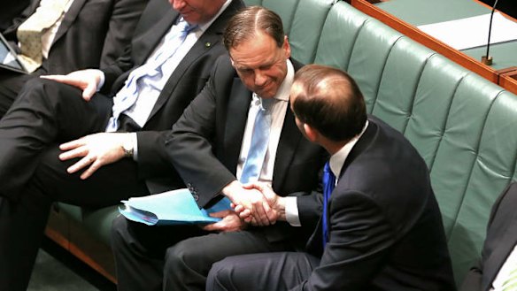 Environment Minister Greg Hunt is congratulated by Prime Minister Tony Abbott after the Carbon Tax Repeal Bill passes the House of Reps on Monday evening. Photo: Alex Ellinghausen