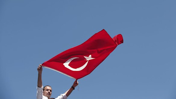 A pro-government supporter waves a Turkish flag during a protest against the attempted coup, in Istanbul.