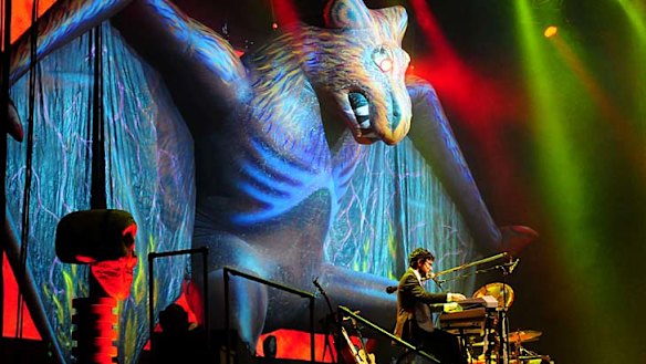 A giant bat with lasers coming from its eyes hovers over the stage.