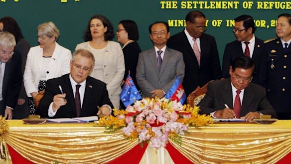 Scott Morrison and Cambodian Interior Minister Sar Kheng signing the agreement. 