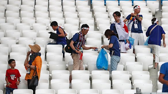 Fair play in the stands, at least: Japanese fans clean up after themselves post-game.