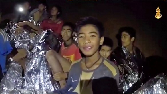 Thai boys smile as a Thai Navy SEAL medic helps the injured in the cave earlier in the week.