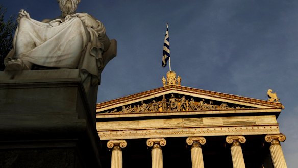 In this photo taken Friday, Oct. 21, 2011, a marble statues of ancient Greek philosopher Plato is seen on a plinth in front of the Athens Academy, as the Greek flag flies. More than 200 international philosophers braved strikes and protests to come to Greece this month to join a forum and debate matters of the mind. Greece's illustrious ancient thinkers built the foundations of Western scholarship, and their philosophy stands as an unquantifiable source of national wealth even during a financial crisis. (AP Photo/Petros Giannakouris)