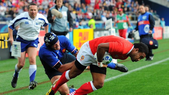 Wing Sukanaivalu Hufanga of Tonga breaks through the challenge of Julien Bonnaire of France to score the opening try.