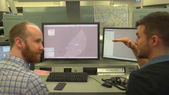 Liam Mannix gets a briefing from air traffic control specialist Sean Menere.