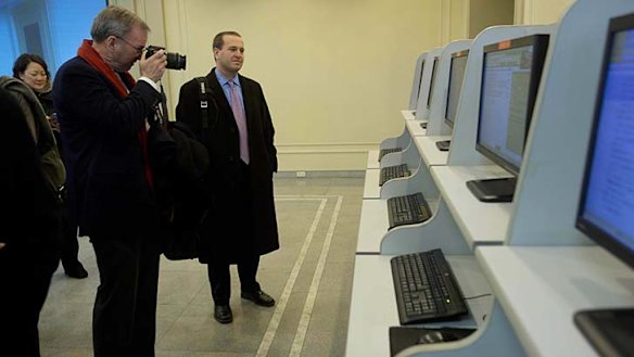Courting the Google chairman ... Eric Schmidt takes photographs as he tours a computer lab.