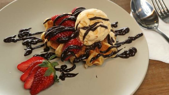 Belgian-style waffle with vanilla ice-cream, strawberries and chocolate sauce.