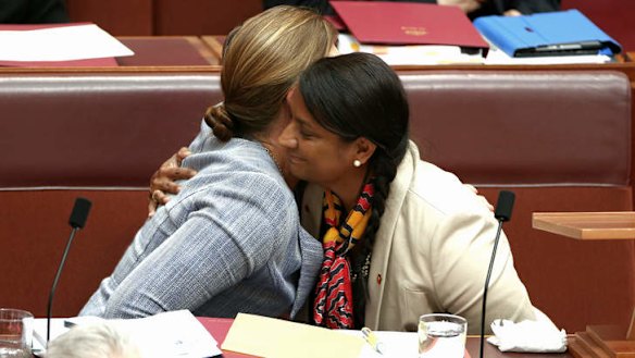 Senator Kate Lundy embraces Senator Nova Peris after she delivered a statement to the Senate on Thursday.