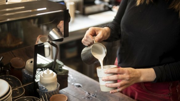Barista Claire serves up a coffee in a keep cup at Something for Jess cafe in Chippendale.  