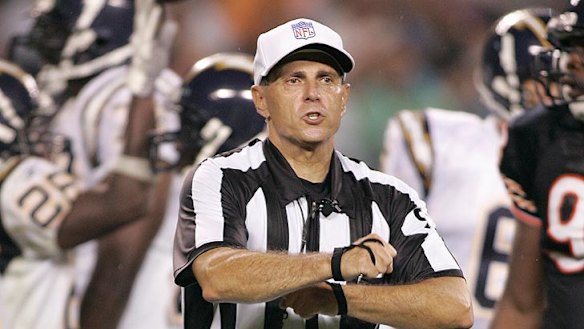 An NFL official explains a decision to the crowd by microphone.