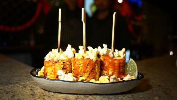 Grilled corn rolled in popcorn or 'lollipop corn'.