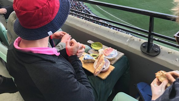 A man who sent social media into meltdown by feasting on an extravagant cheese platter while watching an AFL match at the MCG has broken his silence.