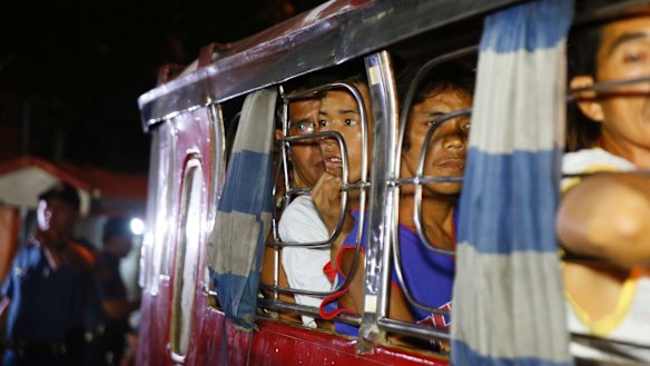 Rounded up male residents from the Tondo slum prepare to be transported to a police station in the continuing "war on drugs".